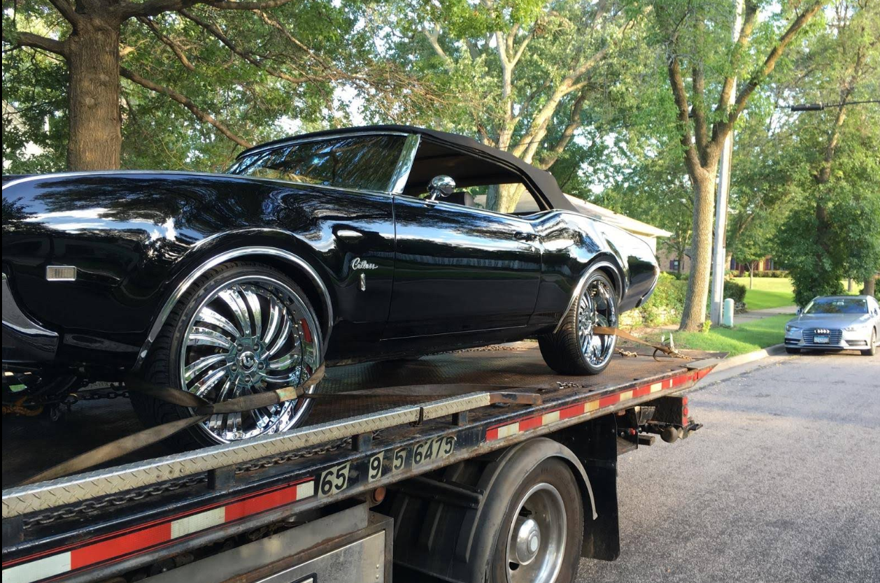 Classic black Cutlass on flatbed for safe transport