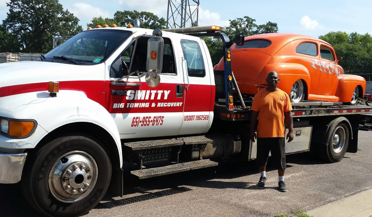 Smitty owner standing proudly next to truck with custom hot rod loaded